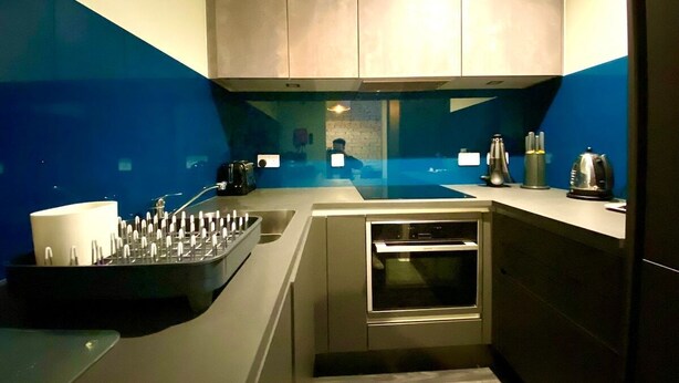 A compact kitchen with a built-in oven, a sink, and a countertop with various appliances.