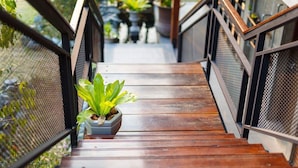 A wooden staircase with metal railings and a potted plant at the bottom. - The Wishes Hotel At Chiangmai Chiang Mai (Chiang Mai)