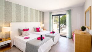 A hotel room with two beds, a desk, a chair, and a view of the outdoors. - Villa with heatable pool, 2 jacuzzis & BBQ (Armação de Pêra)