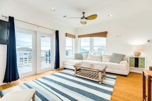 Relax in this spacious living room with a sofa set, coffee table, and wall-mounted TV.