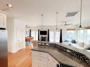 Enjoy meals in the kitchen with a dining area and living space featuring a sofa and TV.