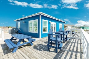 Situated on a wooden deck, this cabin features large windows and comfortable outdoor seating.