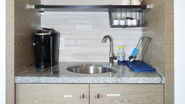 A compact kitchen with a coffee maker, sink, and a sign indicating the availability of Wi-Fi. - Private Modern Suite 15min from YVR self check in (Richmond)