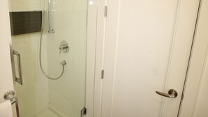 A glass-enclosed shower with a handheld showerhead and a wall-mounted faucet. - Private Modern Suite 15min from YVR self check in (Richmond)