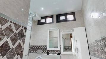 Un baño moderno con inodoro, lavamanos y espejo.