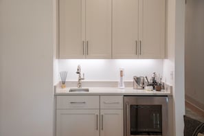 A modern kitchen with white cabinets, a stainless steel refrigerator, and a countertop with various kitchen items. - The SLOHouse, Walk to Sq+Campus, VelvetDitchVillas (Oxford)