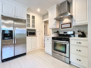 A modern kitchen with stainless steel appliances, white cabinetry, and a built-in oven. - The Sivley 2BR Classic Home by Velvet Ditch Villas (Oxford)
