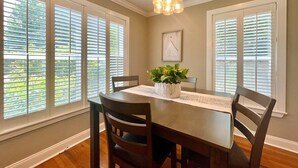 A dining room with a table, chairs, a hanging light fixture, and a potted plant. - The Sivley 2BR Classic Home by Velvet Ditch Villas (Oxford)