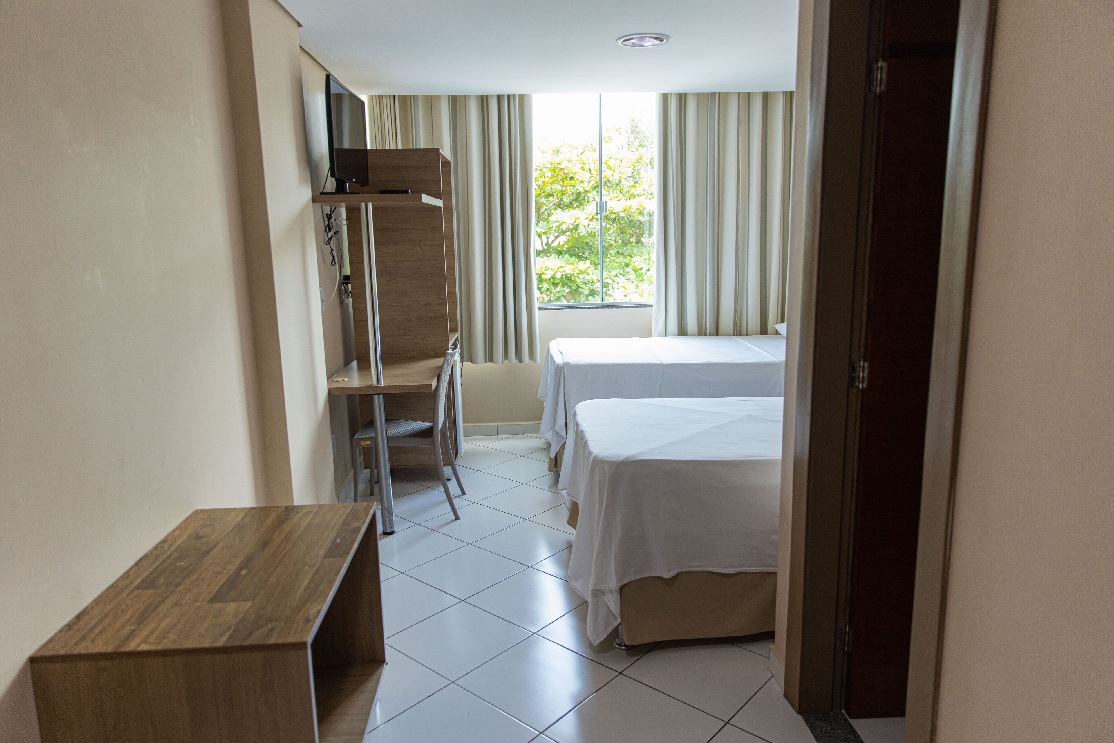 Una habitación de hotel con una cama, un escritorio y una silla.