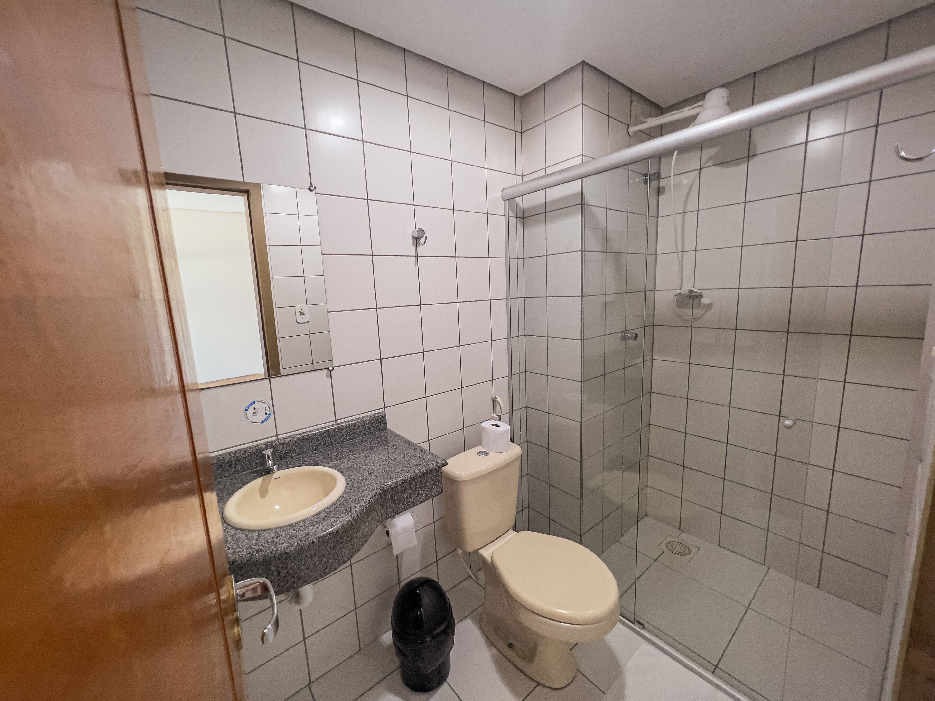 A bathroom with a sink, toilet, and glass-enclosed shower stall.