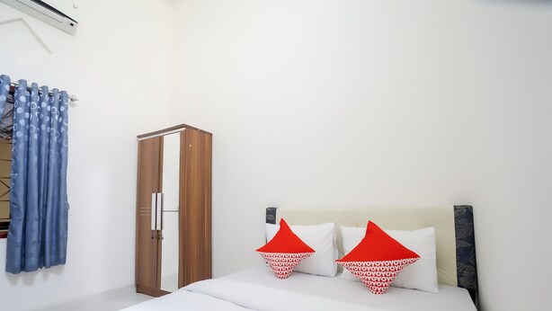 Une chambre à coucher avec un lit, une armoire et un rideau.