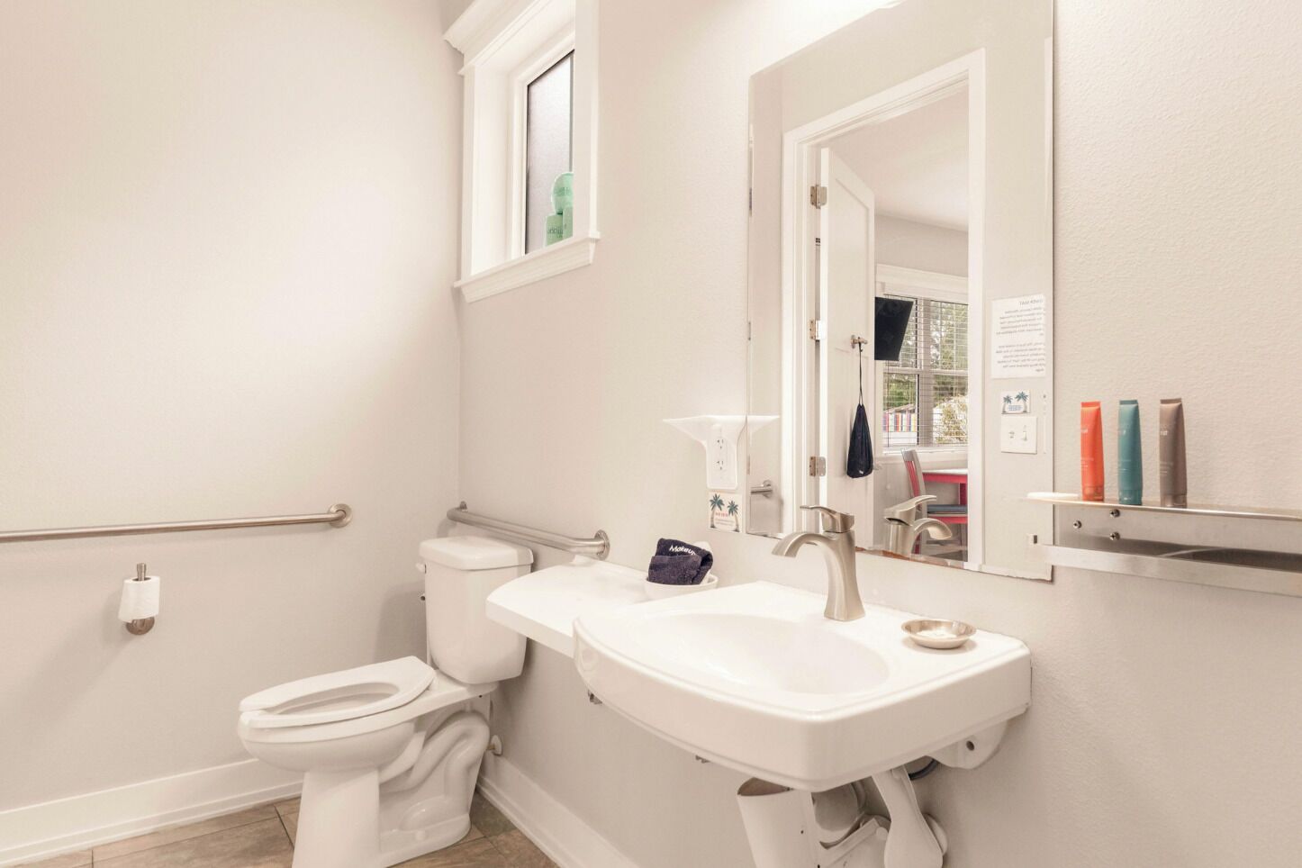 A bathroom with a toilet, sink, and mirror.