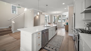 Een moderne keuken met witte kasten, roestvrijstalen apparatuur en een centraal eiland.