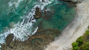 Una playa con costa rocosa y agua cristalina.