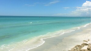 Ein Strand mit klarem, türkisblauem Wasser und einem sandigen Ufer.
