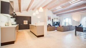 A modern kitchen with a central island, built-in appliances, and pendant lighting. - Luxury & Large Apt. in Siena Resort at Eagle (Trequanda)