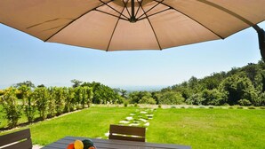 An outdoor seating area with a table, chairs, and a large umbrella. - Luxury & Large Apt. in Siena Resort at Eagle (Trequanda)