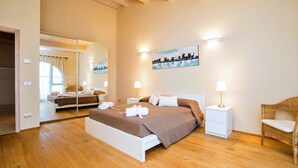 Ein modernes Schlafzimmer mit einem großen Bett, Nachttischen, einem Spiegel und einem Stadtbild.