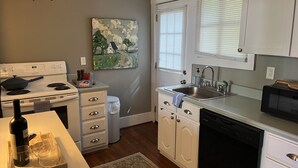 A modern kitchen with white cabinets, a stove, a sink, and a microwave. - Cozy Carriage House 2 Blocks from Oxford Square (Oxford)