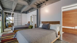 Ein modernes Hotelzimmer mit zwei Betten, einem großen Fenster und Blick auf die Stadt.
