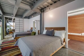Ein modernes Hotelzimmer mit zwei Betten, einem großen Fenster und Blick auf die Stadt.