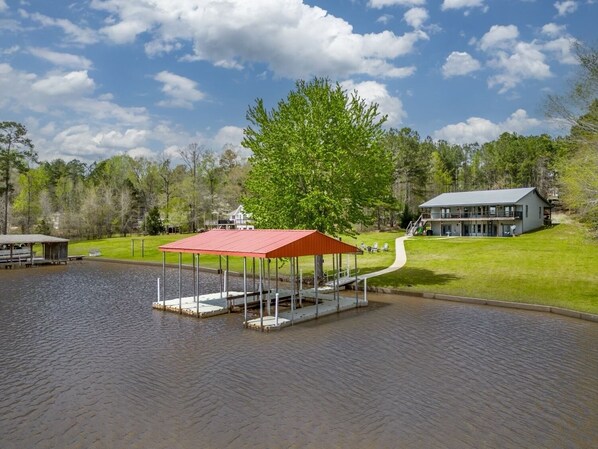 A lakeside property with a dock, a covered pavilion, and a house with a balcony overlooking the water. - Sunset Estate 7 bedrooms, Sleeps 18! + Game Room (Sparta)