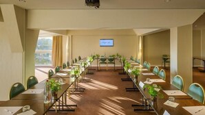 A conference room with a long table, chairs, and a projector screen. - Hotel du Port (Nogent-sur-Marne)