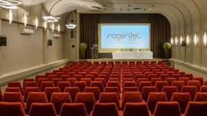 A conference room with rows of red chairs, a projection screen displaying 'nogentel', and modern lighting fixtures. - Hotel du Port (Nogent-sur-Marne)