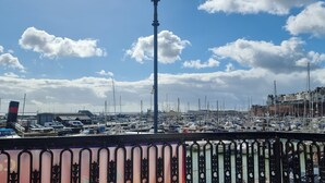 Ein Yachthafen mit vertäuten Booten, eine Straßenlaterne und im Hintergrund eine Gebäudereihe.