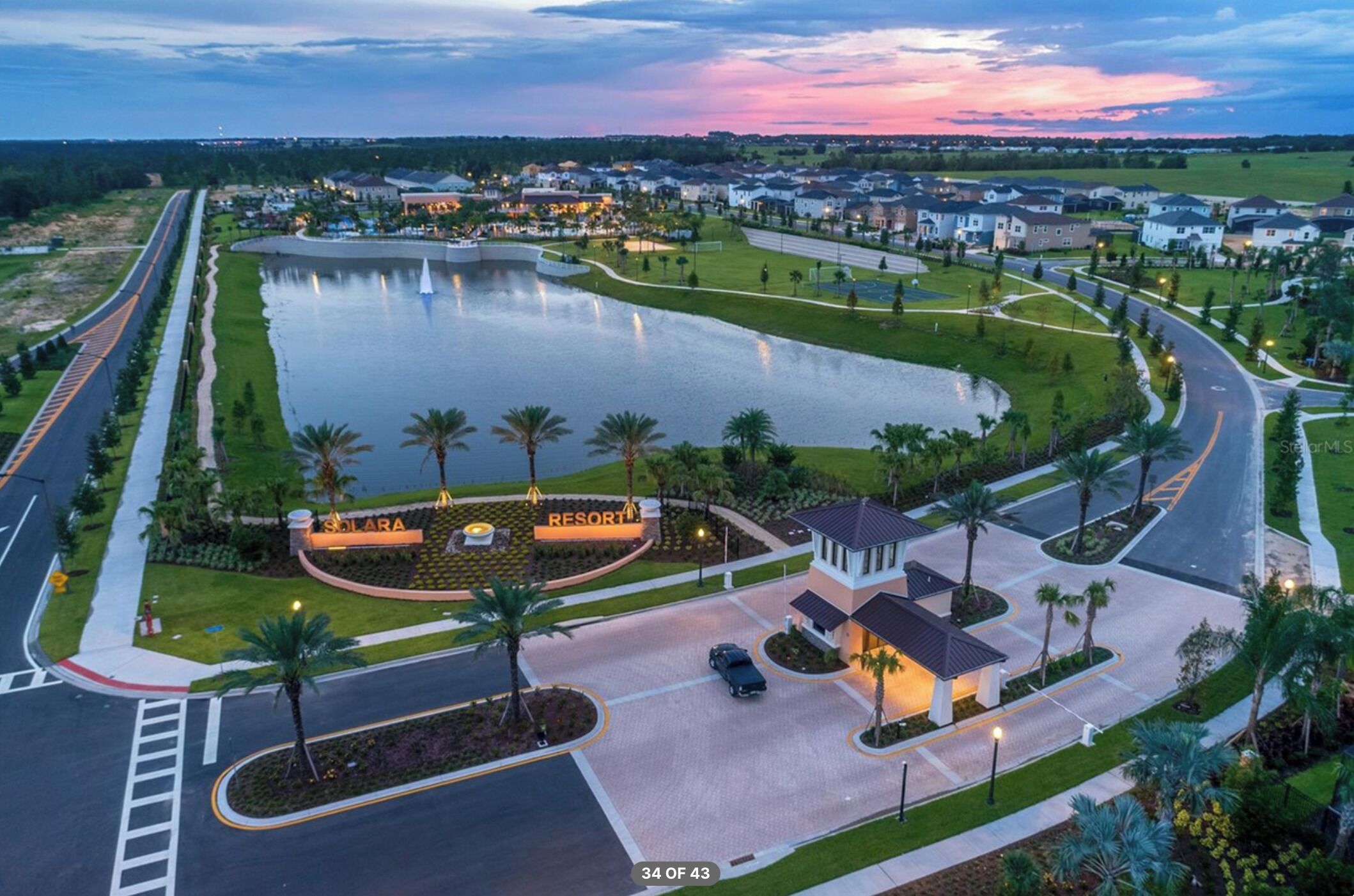 A resort with a large lake, a golf course, and a well-maintained parking area.