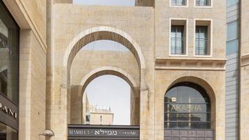 A modern building with a central archway, storefronts for 'MAMMUTI & KAFKA' and 'AKASHA', and a 'PANDORA' store.