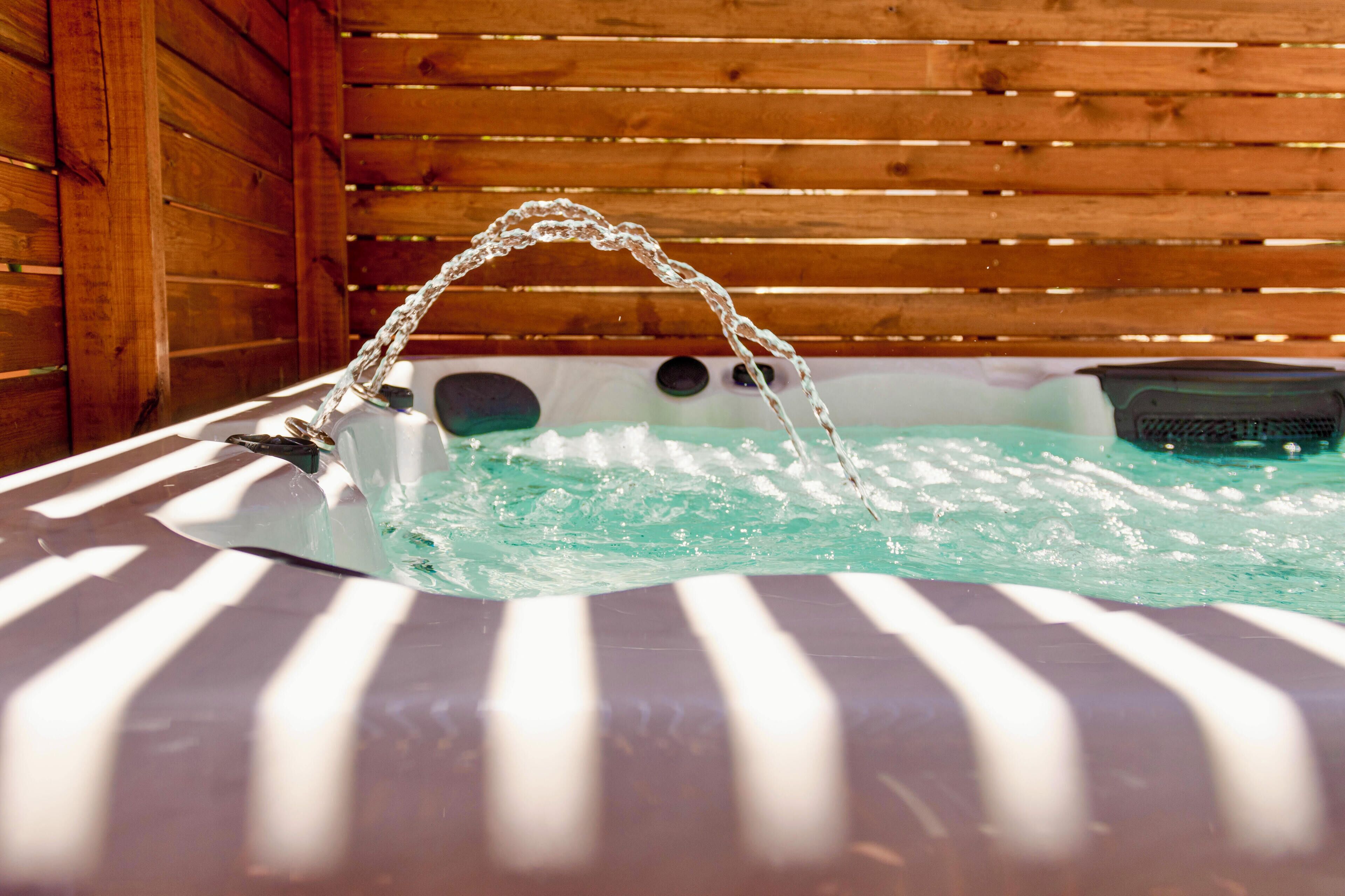 A wooden cabin with a hot tub filled with water.