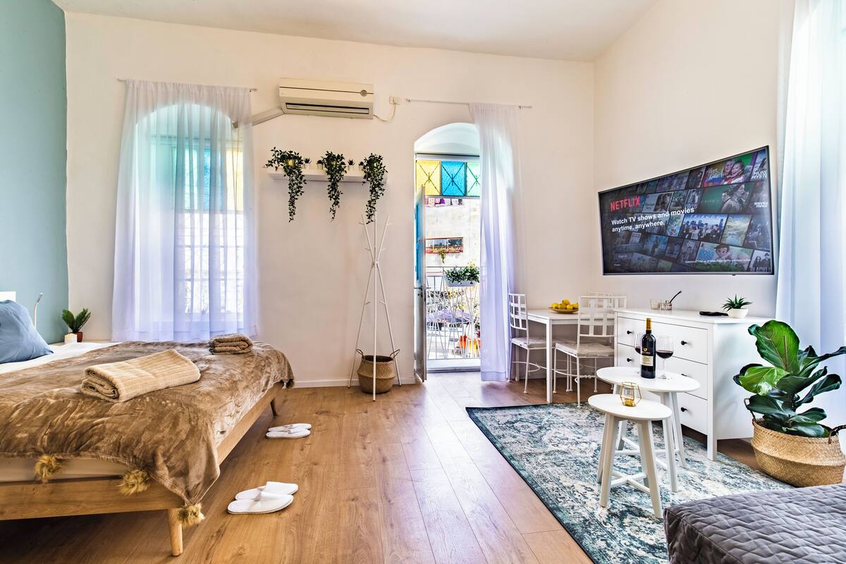 Une chambre à coucher moderne avec un lit, une table de chevet et un téléviseur fixé au mur.