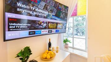 A flat-screen TV mounted on a wall displaying a Netflix interface with various shows and movies.