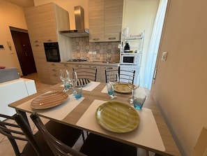 Una cocina moderna con comedor listo para cuatro personas.