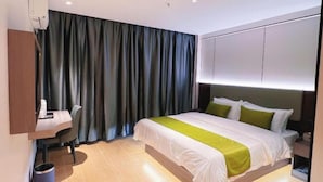 A modern hotel room with a bed, a desk, and a chair. - Green Tree Inn Zhixuan Hotel (Nanning)
