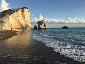 A beach with a large rock formation and calm sea. - Escape to The Retreat -3 bed Villa, private fenced pool (Pissouri, Cyprus)