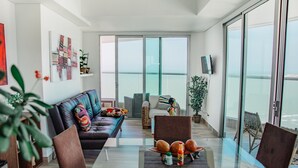 A modern living room with a glass dining table, leather sofa, and a balcony with a view. - Playa Cartagena (Cartagena)