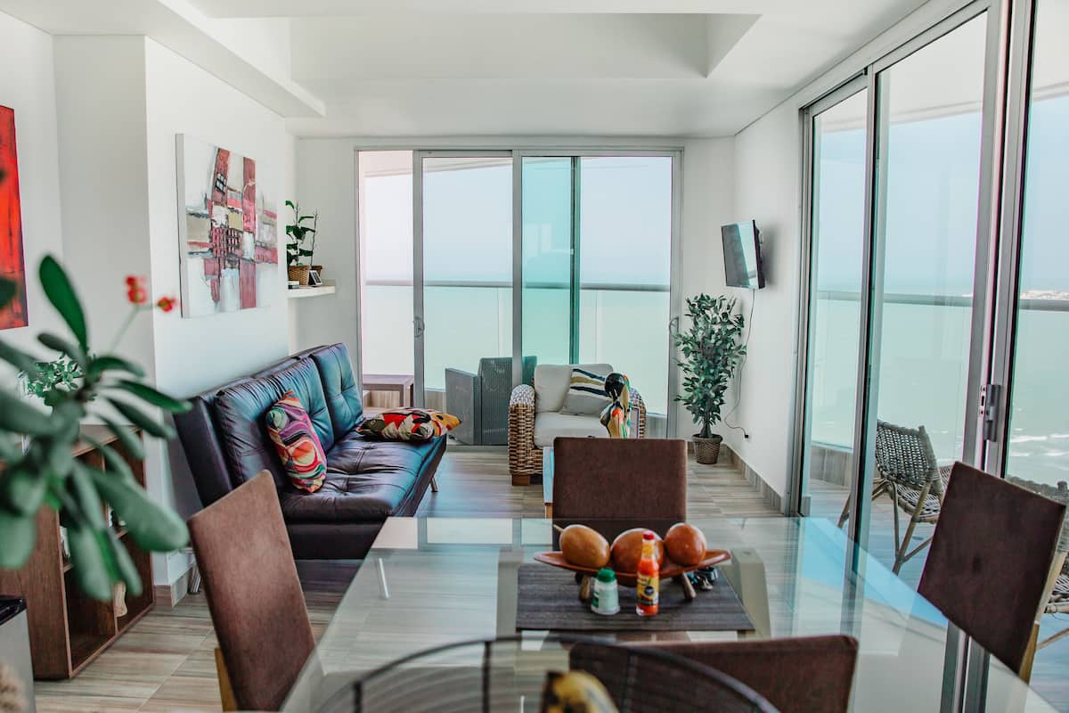 Luxe suite, 2 slaapkamers, uitzicht op oceaan, langs het strand | Woonruimte | Een smart-tv en slimme speakers