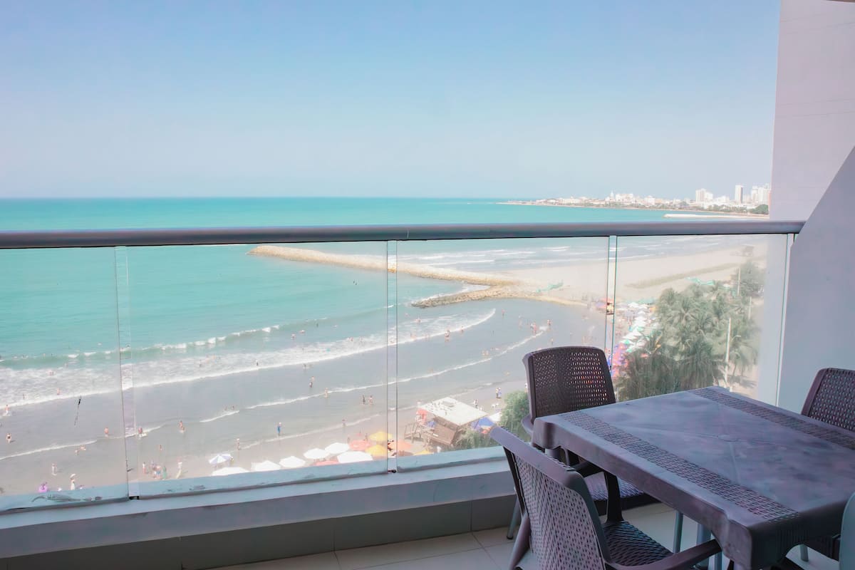 A balcony with a view of a beach and cityscape.