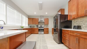 Una cocina moderna con armarios de madera, electrodomésticos de acero inoxidable y una isla grande.