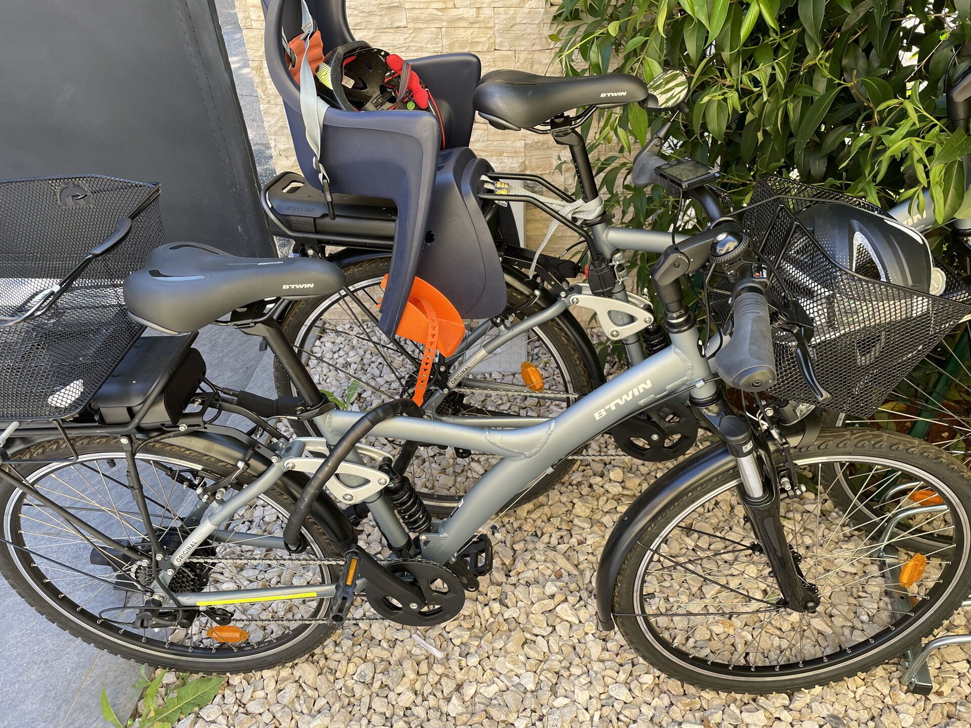 A stationary bicycle with a basket and a helmet stored on the seat.
