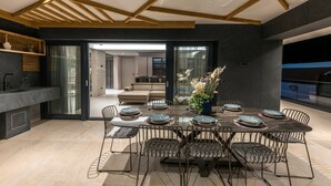 Un comedor moderno con una mesa rectangular dispuesta para seis personas, rodeada de sillas de metal con asientos acolchados.
