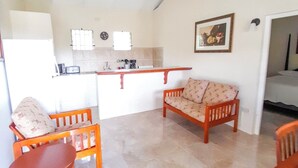 A compact living space with a kitchenette, a ceiling fan, a sofa, and a dining table. - The Grenada Escape (Saint George)