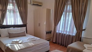 Una habitación de hotel con una cama, un sofá, un escritorio y un armario.