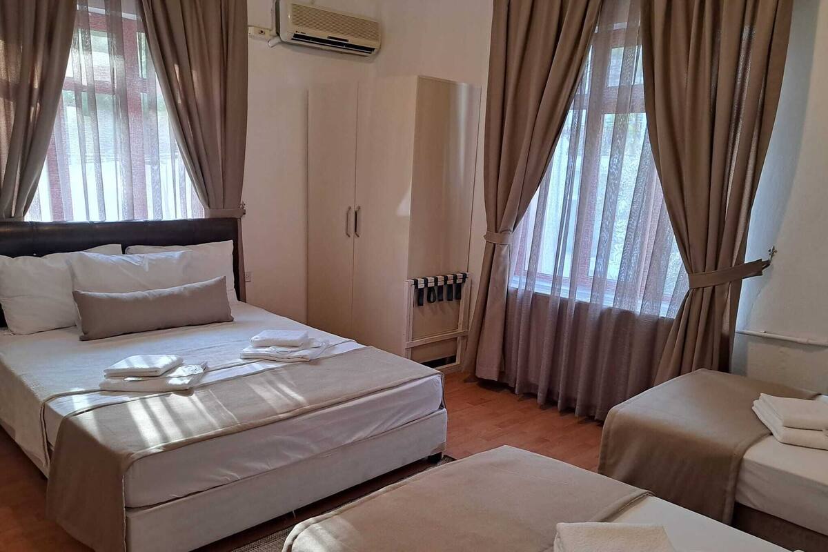 Une chambre d’hôtel avec un lit, un canapé, un bureau et une armoire.