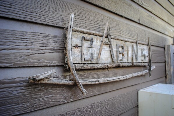 A rustic wooden sign with the word "CABIN" on a weathered wall.