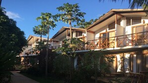 Un resort con edificios de varios pisos, balcones de madera al aire libre y abundante vegetación.