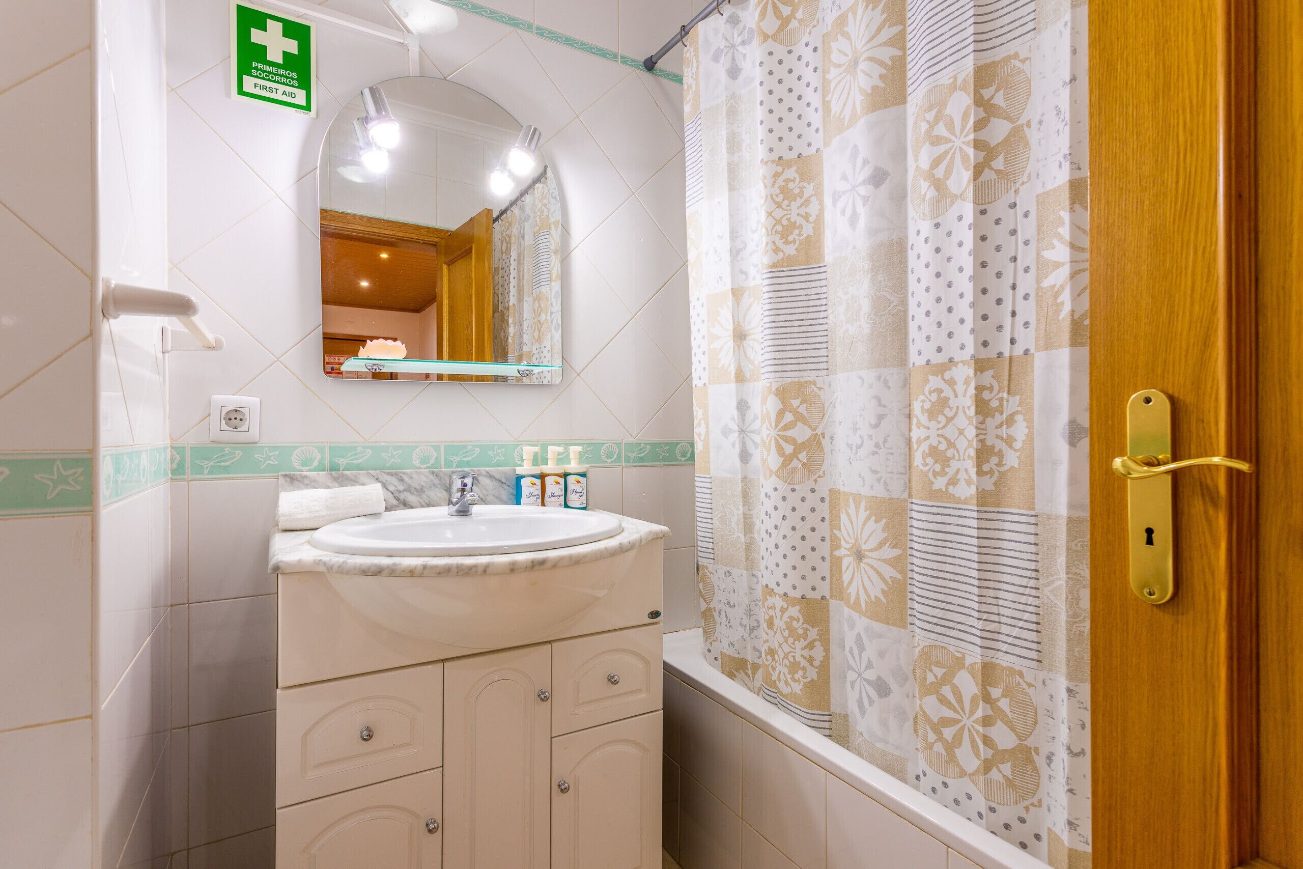 Ein Badezimmer mit Waschbecken, Spiegel und Duschvorhang.