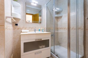 Bathtub, hair dryer, shampoo, toilet paper